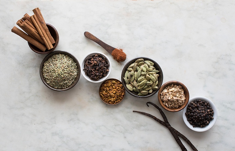 Herbs and spices in bowls on counter with an overhead view