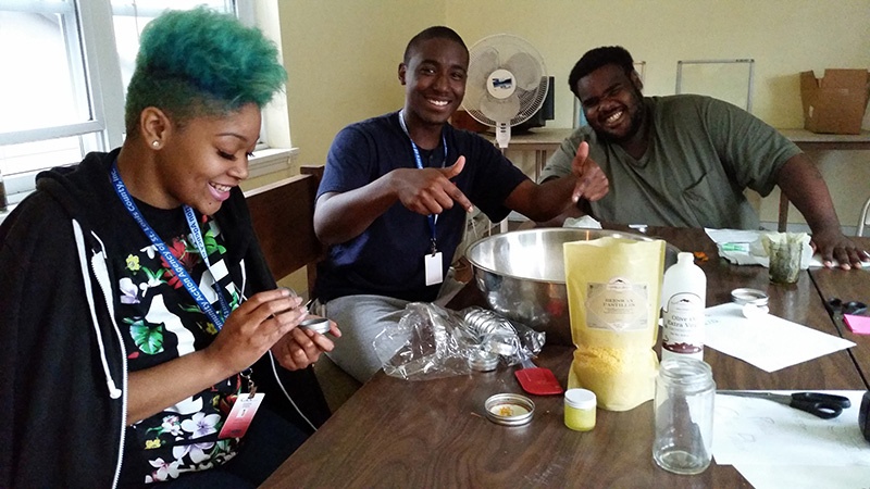 Teens smiling and making herbal preparations at the St. Louis Seeds of Hope Farm