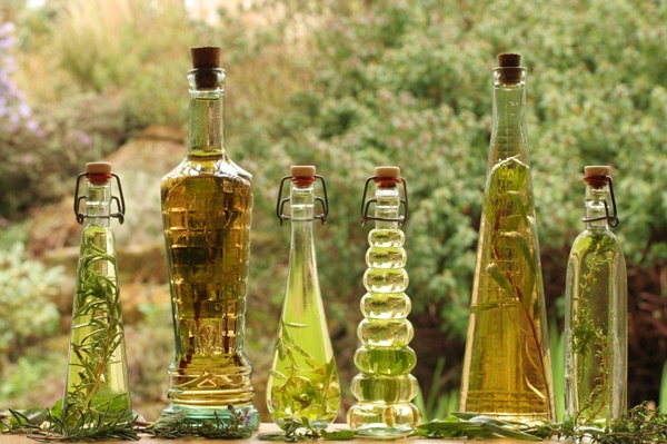 Bottles of oil with herbs infusing on a window sill