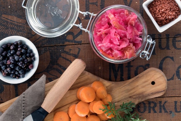 Ingredients for Red Alaea Sauerkraut including bowl of juniper berries and jar of colored cabbage