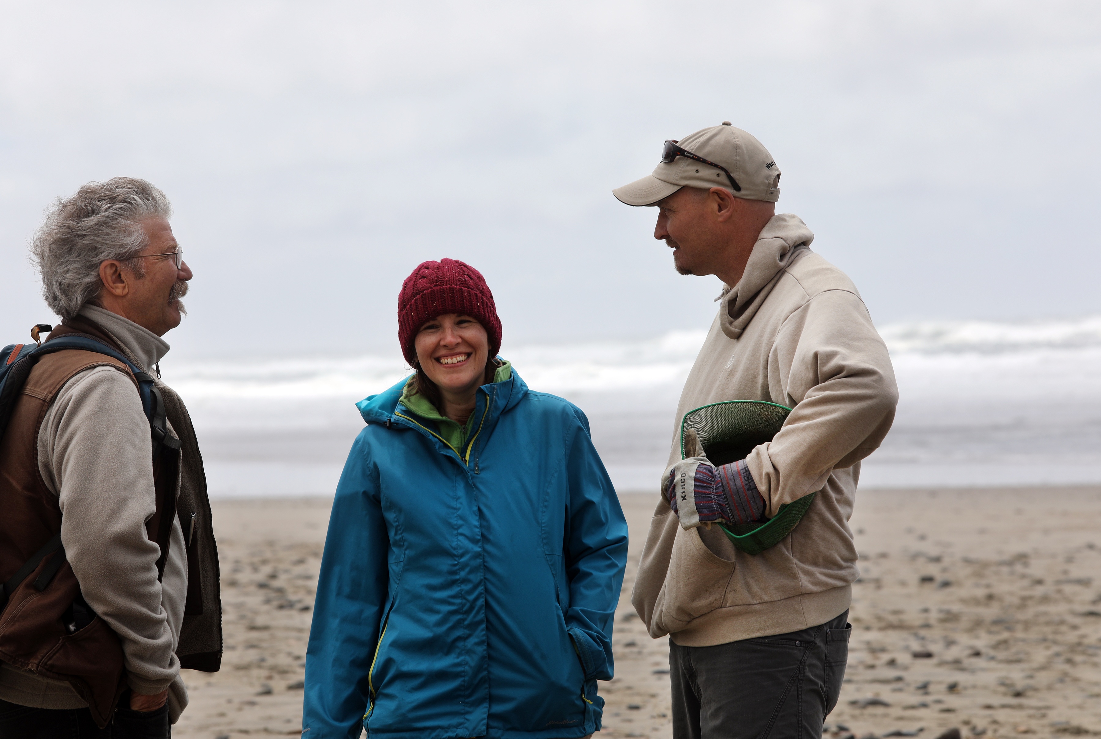 Jonathan talking to people at the beach with ocean and horizon in background