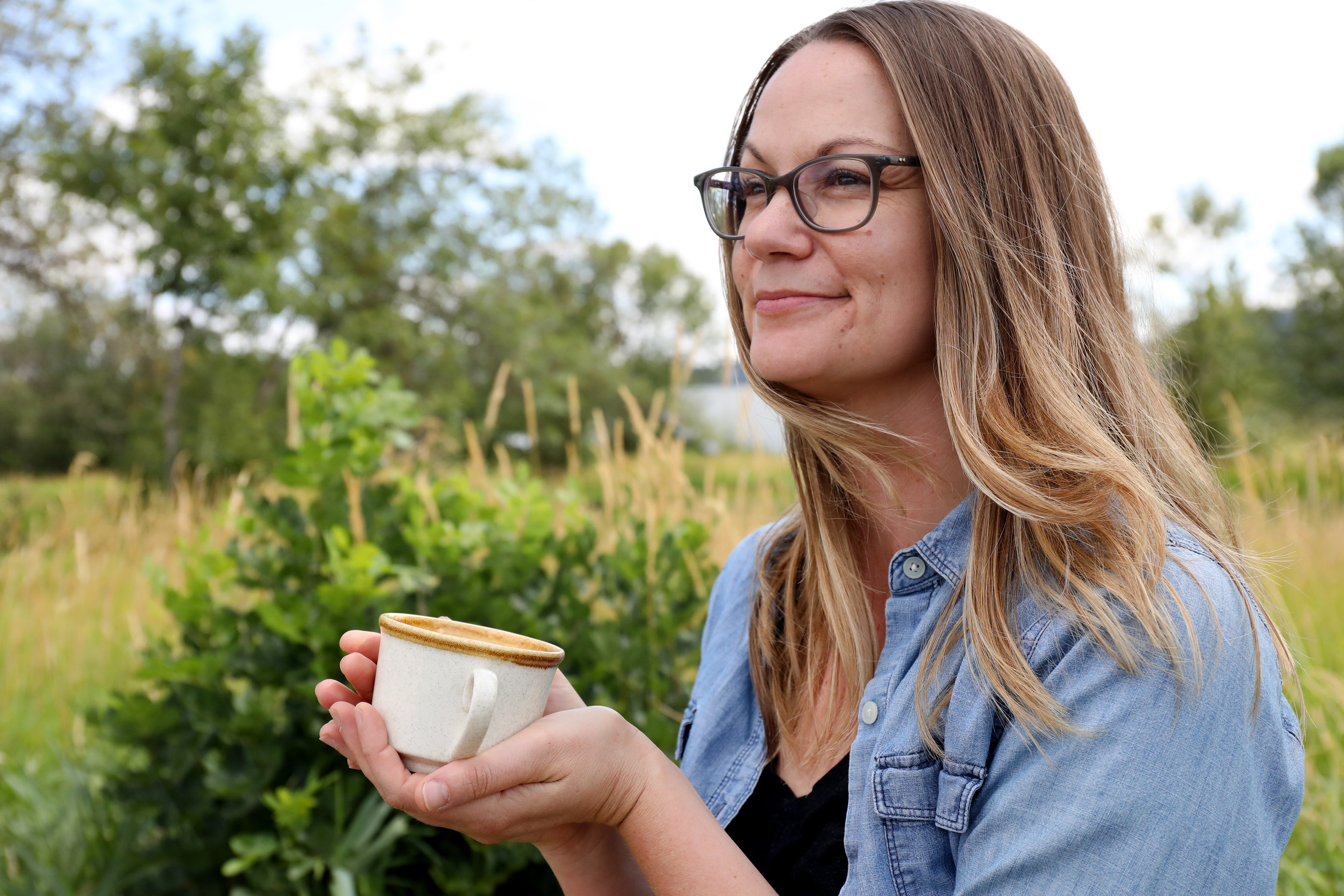 Production manager of Mountain Rose Herbs, Julie DeBord, sips a cup of organic herbal tea near the protected wetlands at our facilities in Eugene, Oregon. 