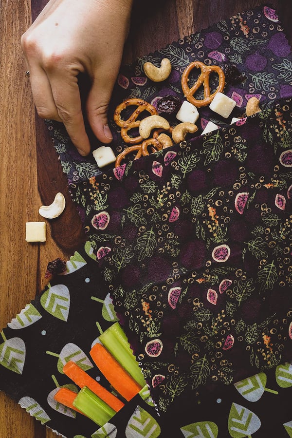 hand grabbing snack piece out of beeswax wrap