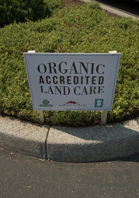 Sign on grass saying Organic Accredited Land Care at Mountain Rose Herbs headquarters and facilities