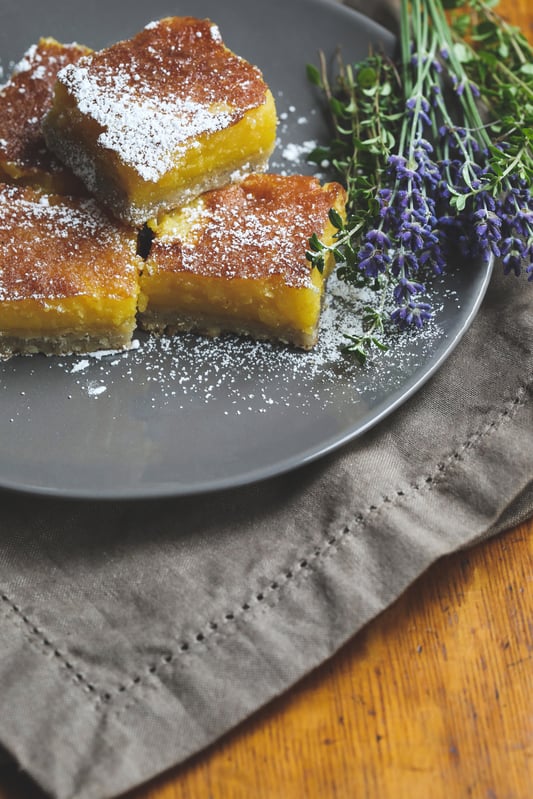 Lemon lavender bars on plate with lavender flowers 