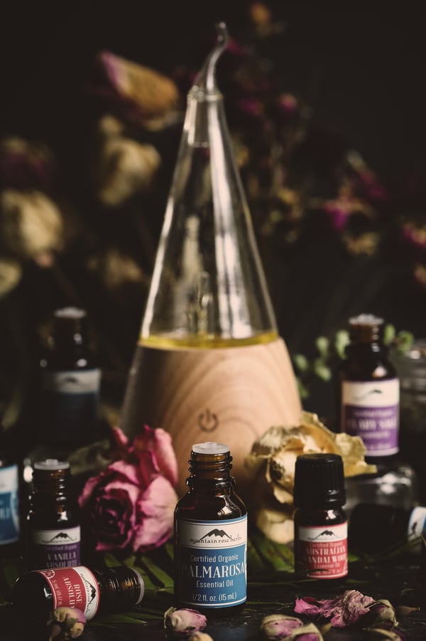 Ziba waterless essential oil diffuser surrounded by bottles of essential oils.