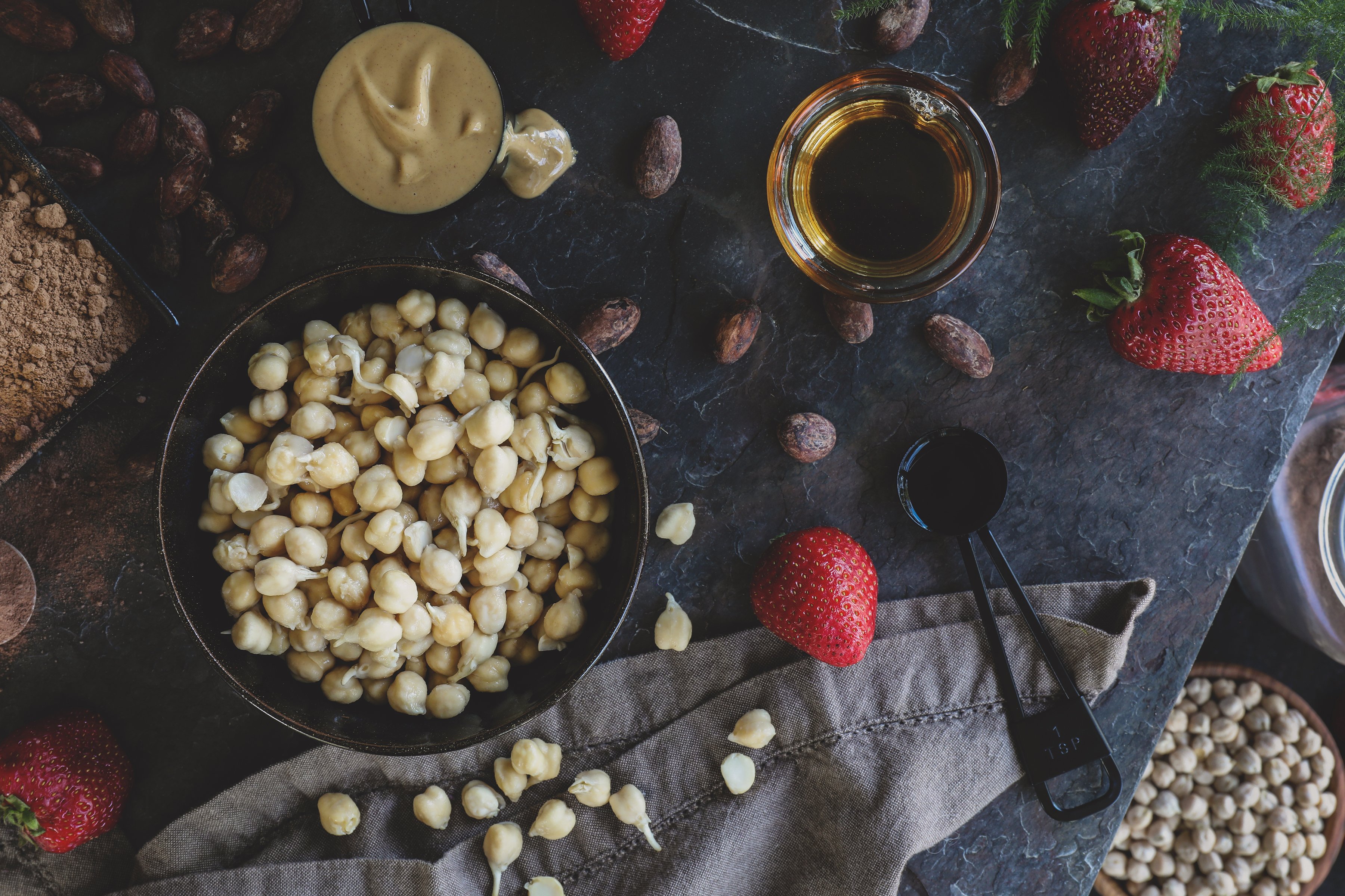 Bowl of sprouted chickpeas, fresh strawberries, and misc. other ingredients needed to make recipe. 