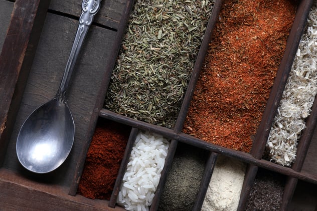 Spices and Ingredients used to make gumbo sitting in organizer with spoon