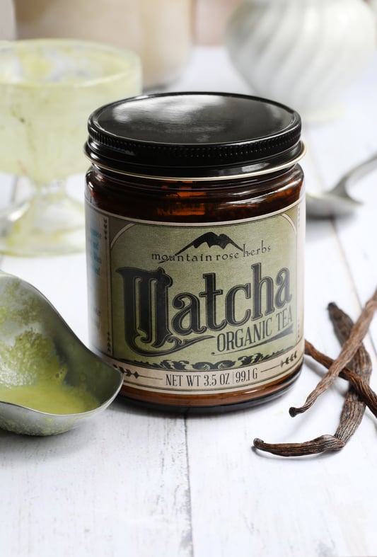 Jar of Mountain Rose Herbs Matcha powder laying next to vanilla beans