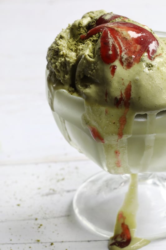 Matcha Green Tea Ice Cream scoop in crystal bowl melting over edges
