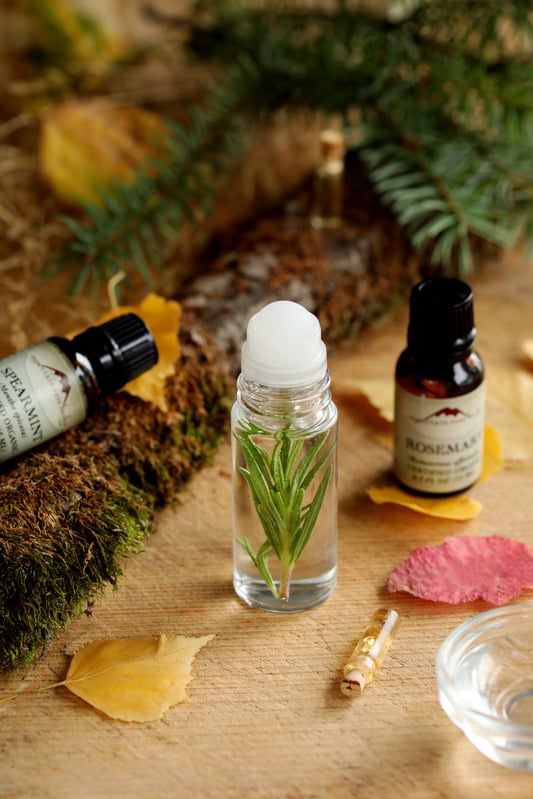 A fall essential oil blend in a roll-top bottle includes rosemary essential oil, spearmint essential oil, and scotch pine essential oil for a woodsy, forest aroma.