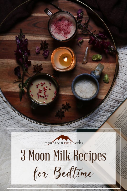 Pinterest link to Mountain Rose Herbs. A trip of moon milk nighttime beverages on a tray with herbs and a lit candle. Moon milk beverages promote relaxation using calming herbs and adaptogens. 