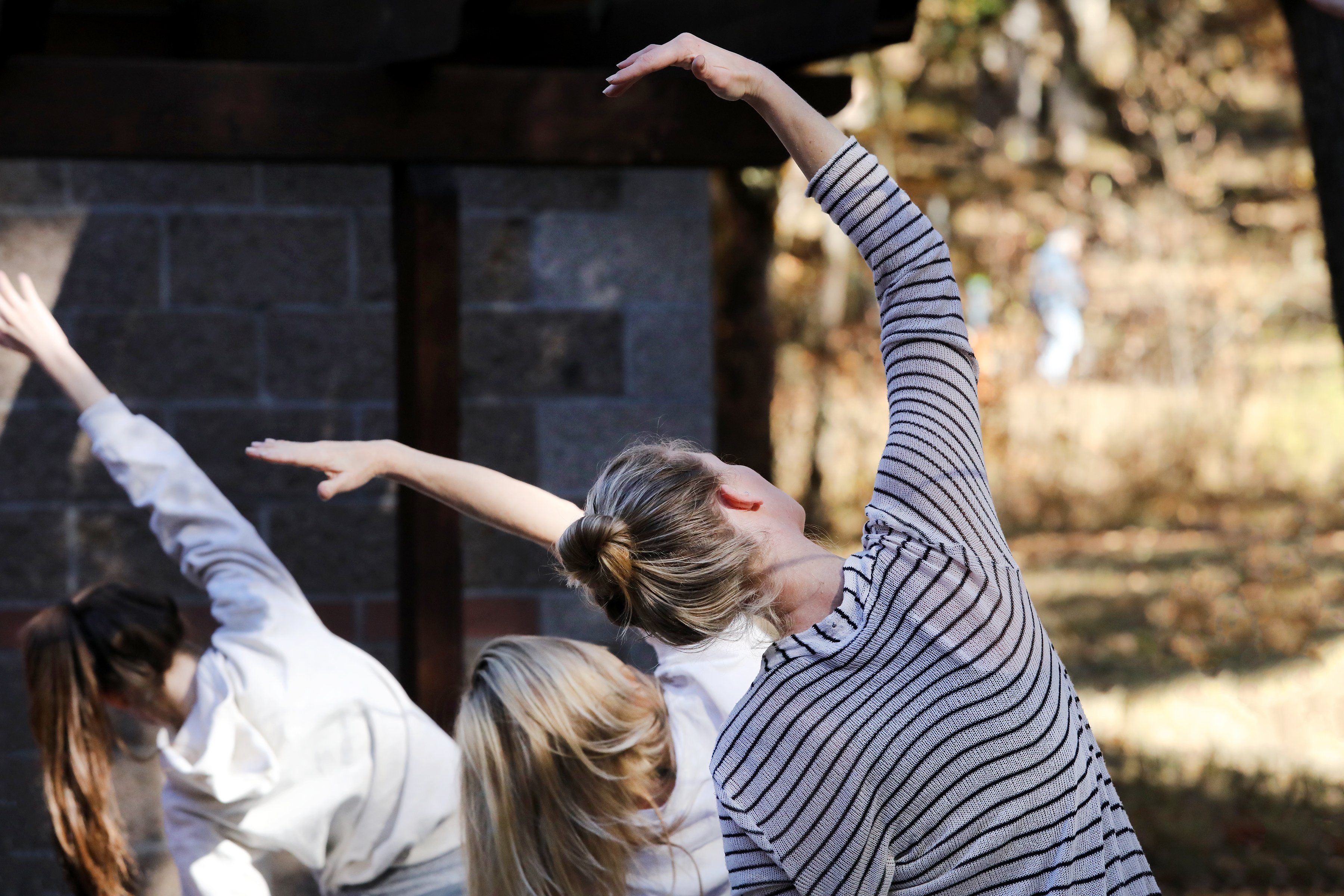 Group of young women doing yoga in outdoor setting. 