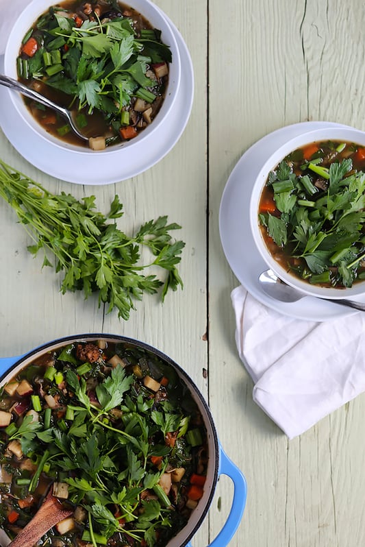 Bowls filled with mushroom tonic soup and topped with cilantro