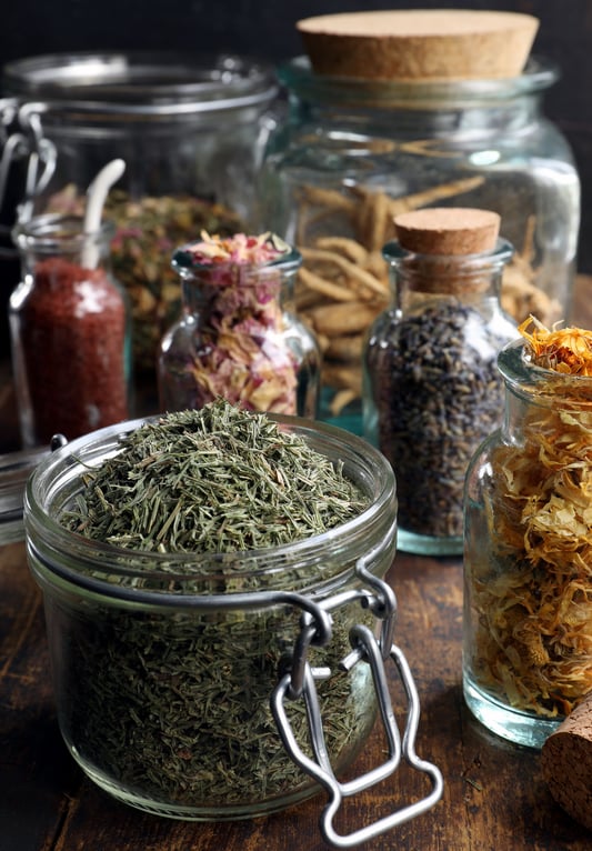 Glass pantry jars with bulk herbs and spices in them