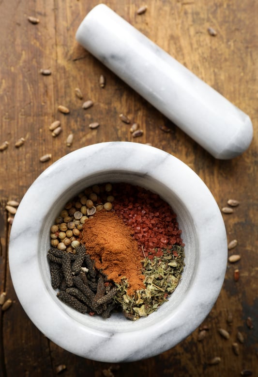 Whole dried herbs in mortar with pestle 