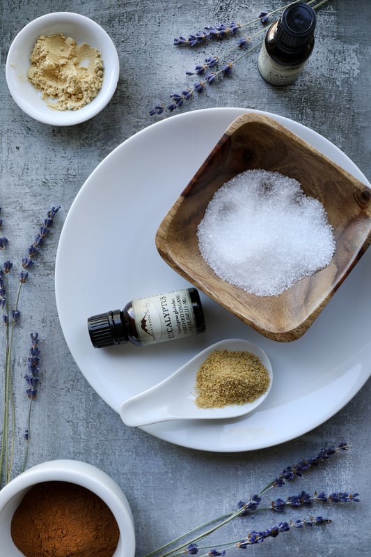 Ingredients for bath salts on rustic table with sprigs of lavender