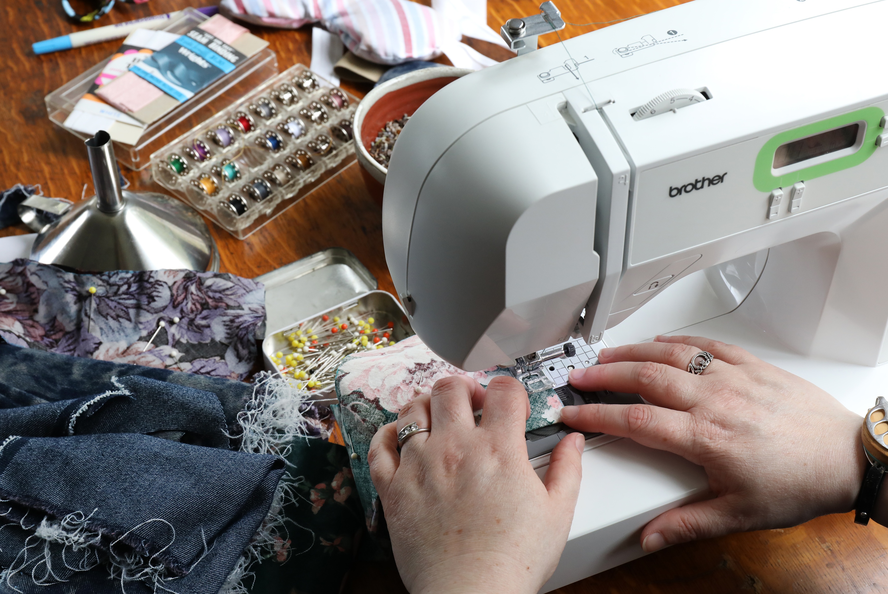 hands on sewing machine sewing fabric to make buckwheat lavender eye pillows