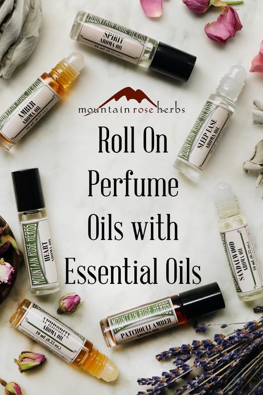 Pinterest link to Mountain Rose Herbs for its line of all natural essential oil roll on perfumes. Various roll-on aroma oils arranged with dried rose buds and sage leaves. 
