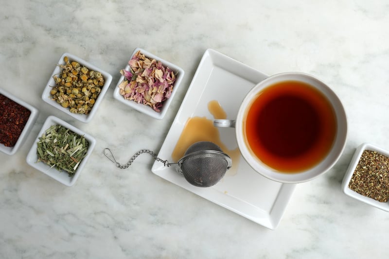 Rooibos Tea in TeaCup with mesh ball tea infuser and ceramic jars of bulk herbs