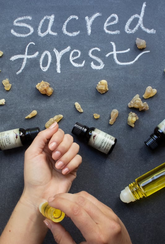 Hands rubbing aroma oil on wrist sacred forest essential oil fragrance recipe