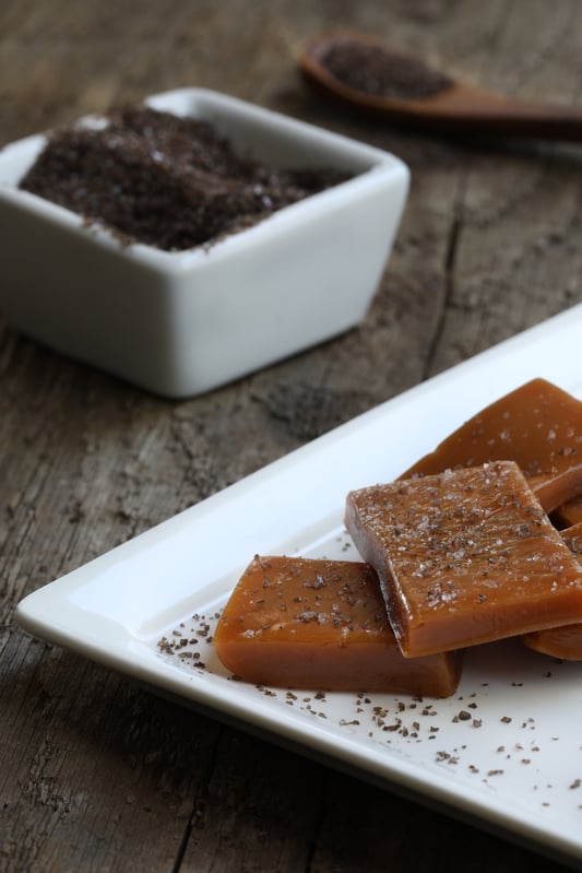 White plate of homemade caramel squares sprinkled with smoked sea salt