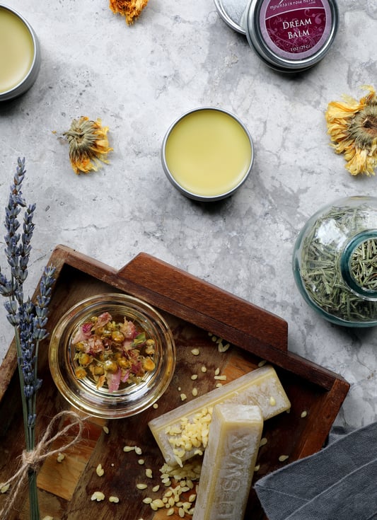 Dream balm salve sitting on counter with beeswax and other salve ingredients