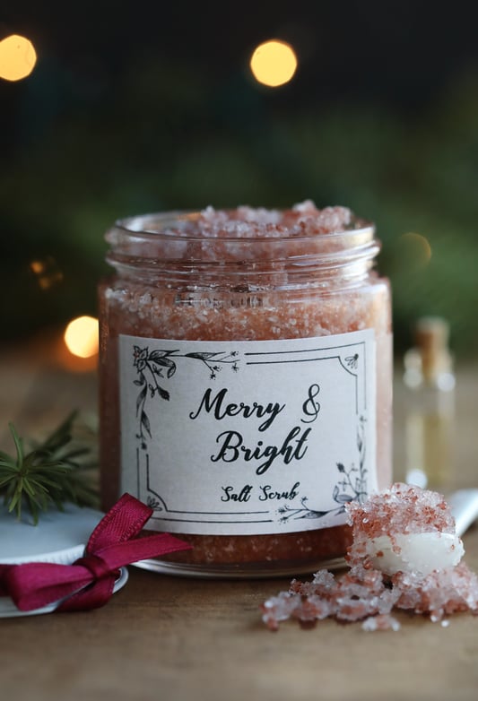Glass jar filled with pink bath salts with words Merry and Bright Salt Scrub with homemade label