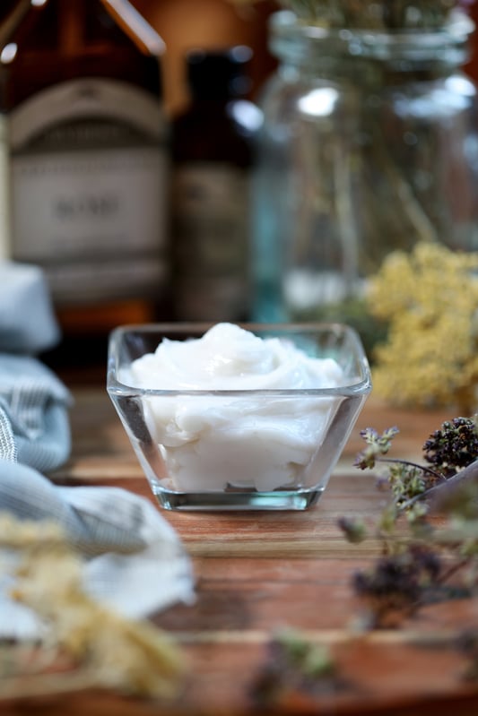 Homemade face moisturizer with rosehip seed oil in glass bowl with ingredients.