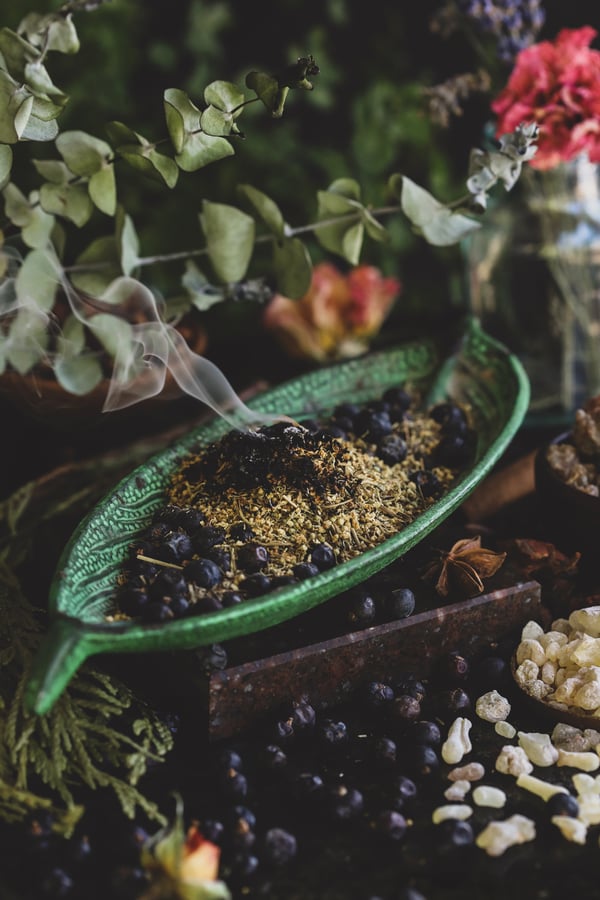 Smoke cleansing herbs and resins smoking in a bowl.