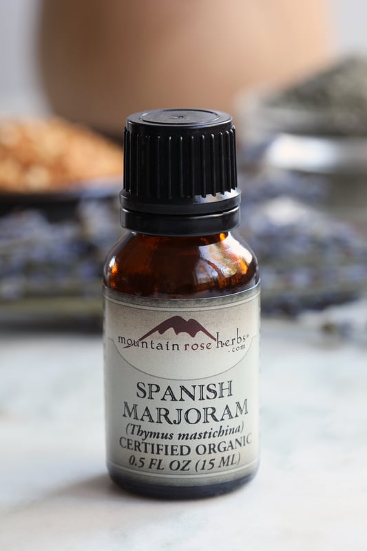 Half ounce bottle of spanish marjoram essential oil sitting on counter