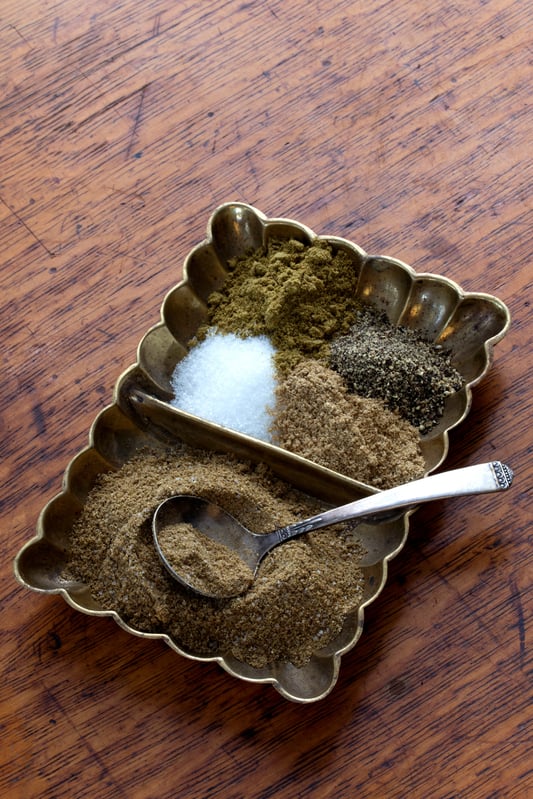Punjabi Spice blend with cumin powder, coriander powder, black pepper, salt in a copper dish with a spoon on the table