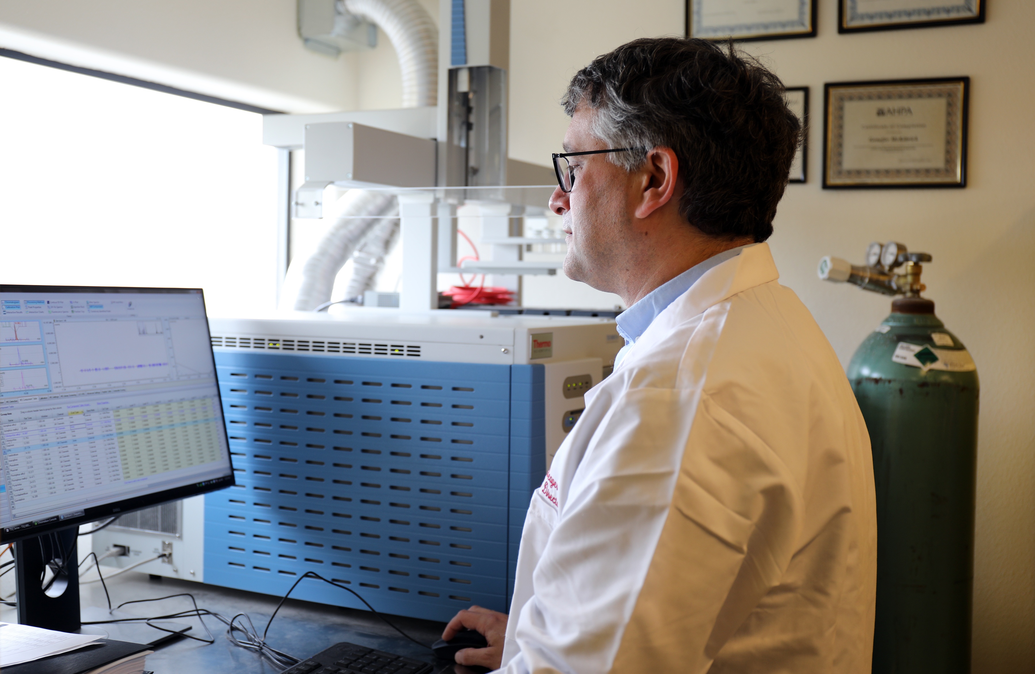 Quality assurance and quality control director looking at data on a computer