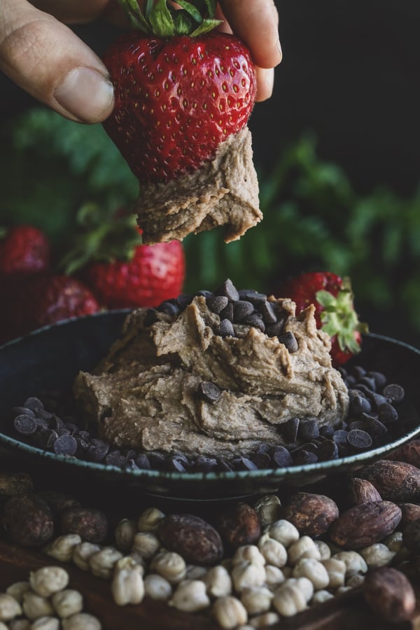 Strawberry being dipped in chocolate dessert