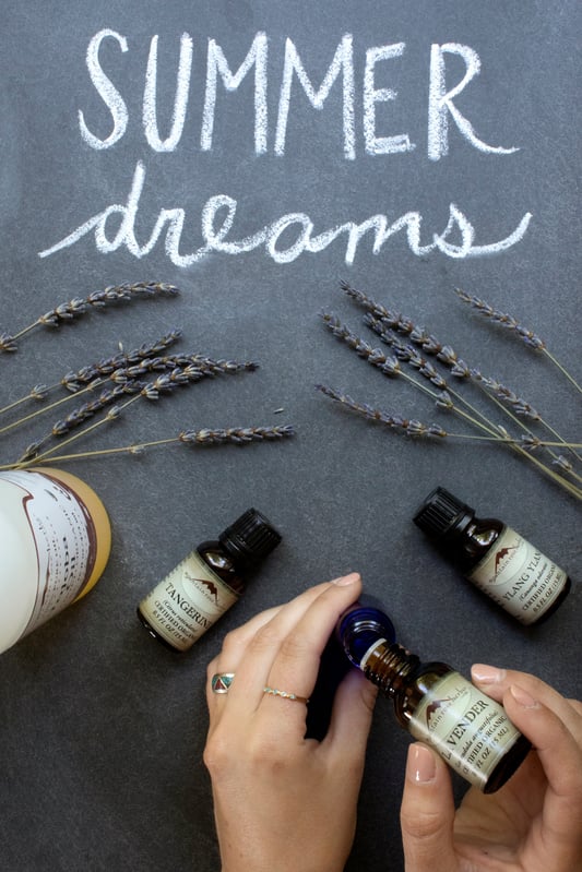 Hands putting drops of lavender essential oil into small glass bottle Summer Dreams essential oil fragrance recipe