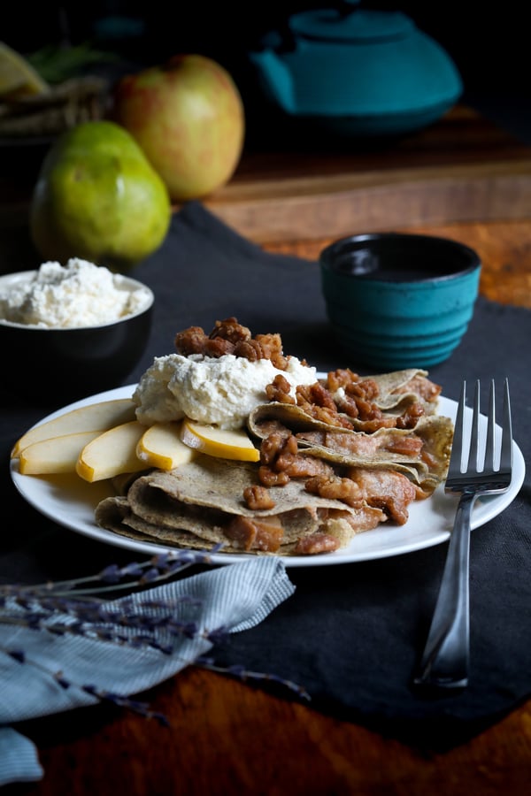 Gluten-free coconut buckwheat crepes with fried apples, sliced pears, spiced nuts and coconut cream.