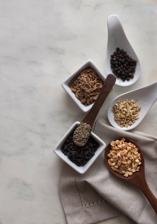 Small bowls and spoons with different colored botanicals. 