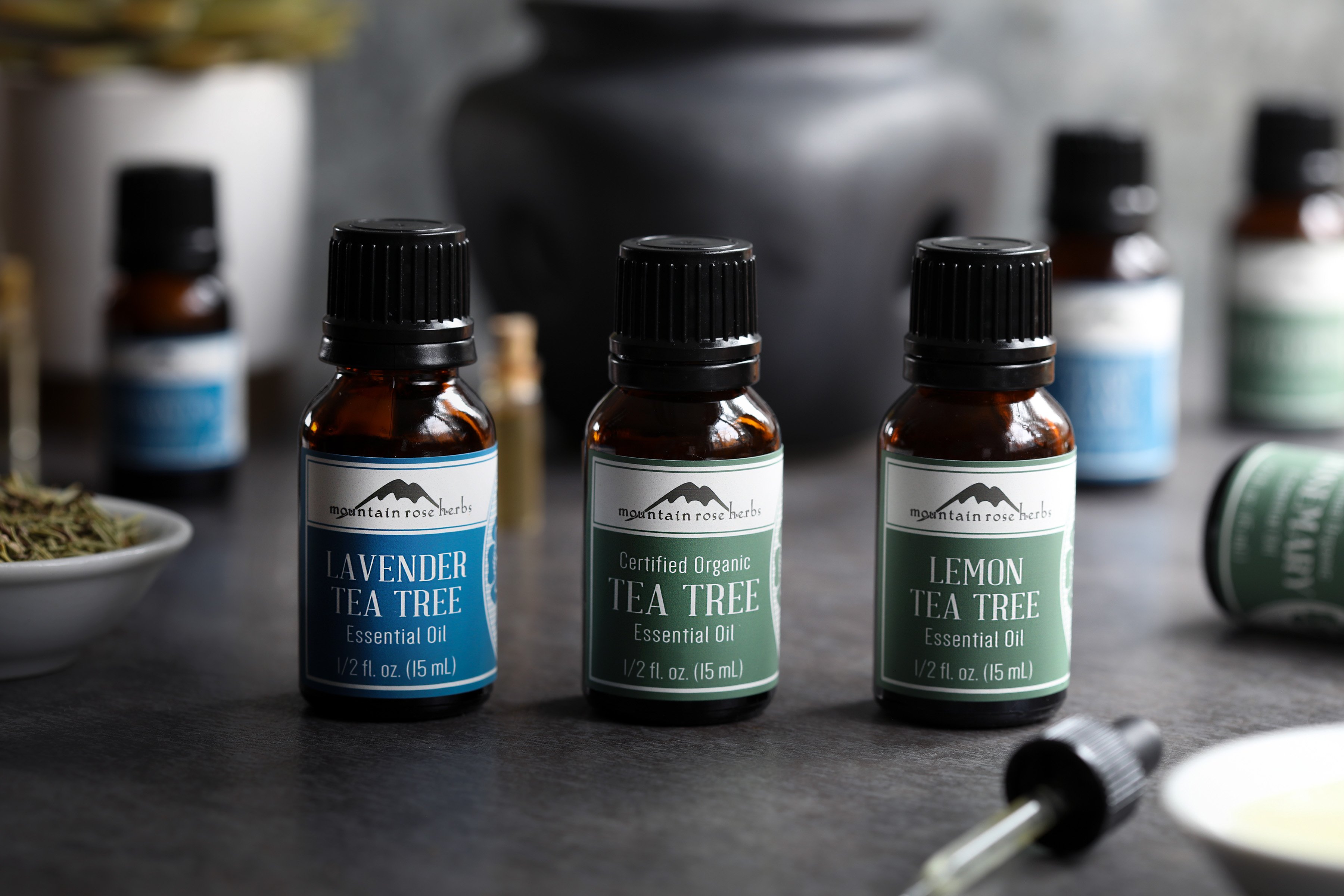 Organic tea tree essential oils include tea tree essential oil, lavender tea tree essential oil, and lemon tea tree essential oil. Packed in amber glass bottles with brightly colored labeling. 