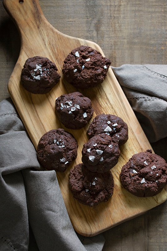 chocolate cookies on a cutting board with sprinkles of salt