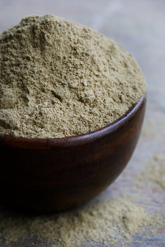 Wooden bowl full of organic triphala powder