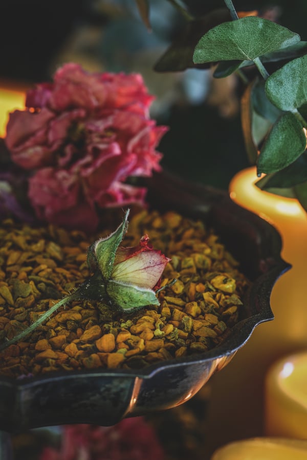 Tumeric root in a bowl with red roses.