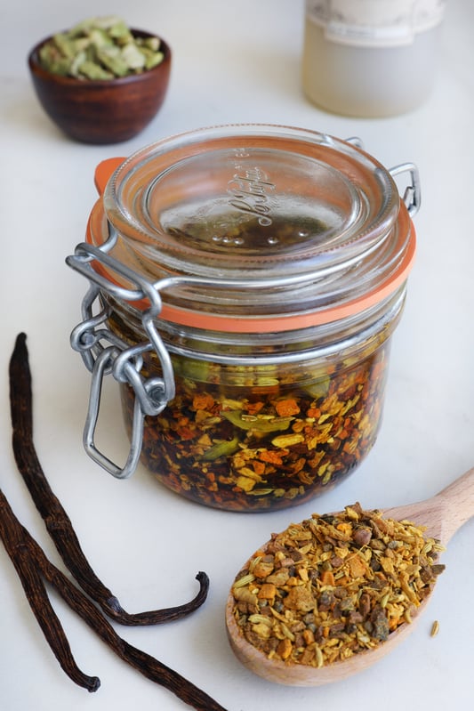 Glass pantry jar with turmeric chai tea blend infused in oil with vanilla beans