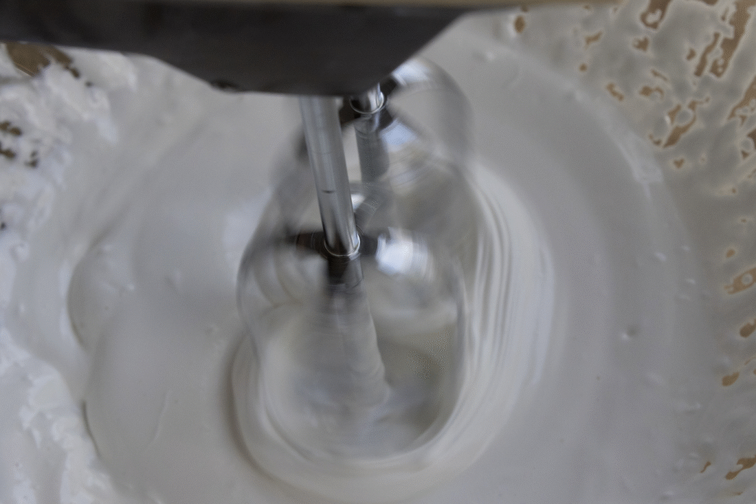 GIF of electric hand mixer whipping fluffy white body butter.