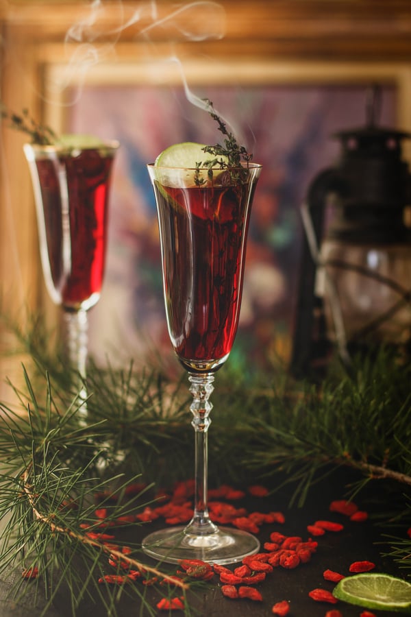 Goji berry-infused rum cocktails sitting amidst Douglas fir boughs