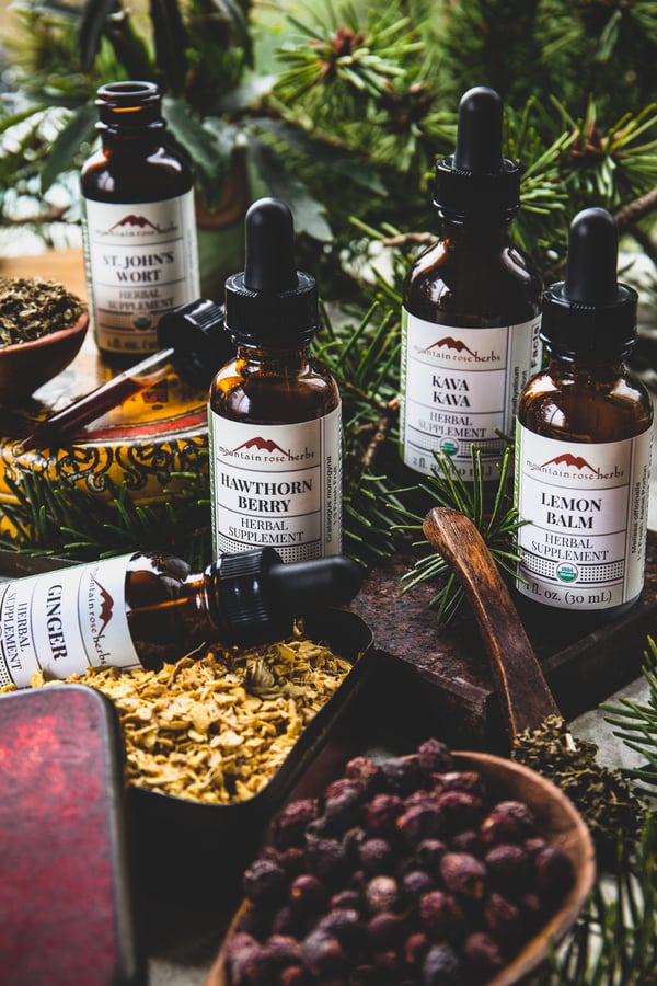 Tinctures and herbs gathered together to make an herbal extract for the winter blues.