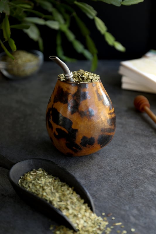Yerba mate in a traditional mate gourde with bombilla straw. 