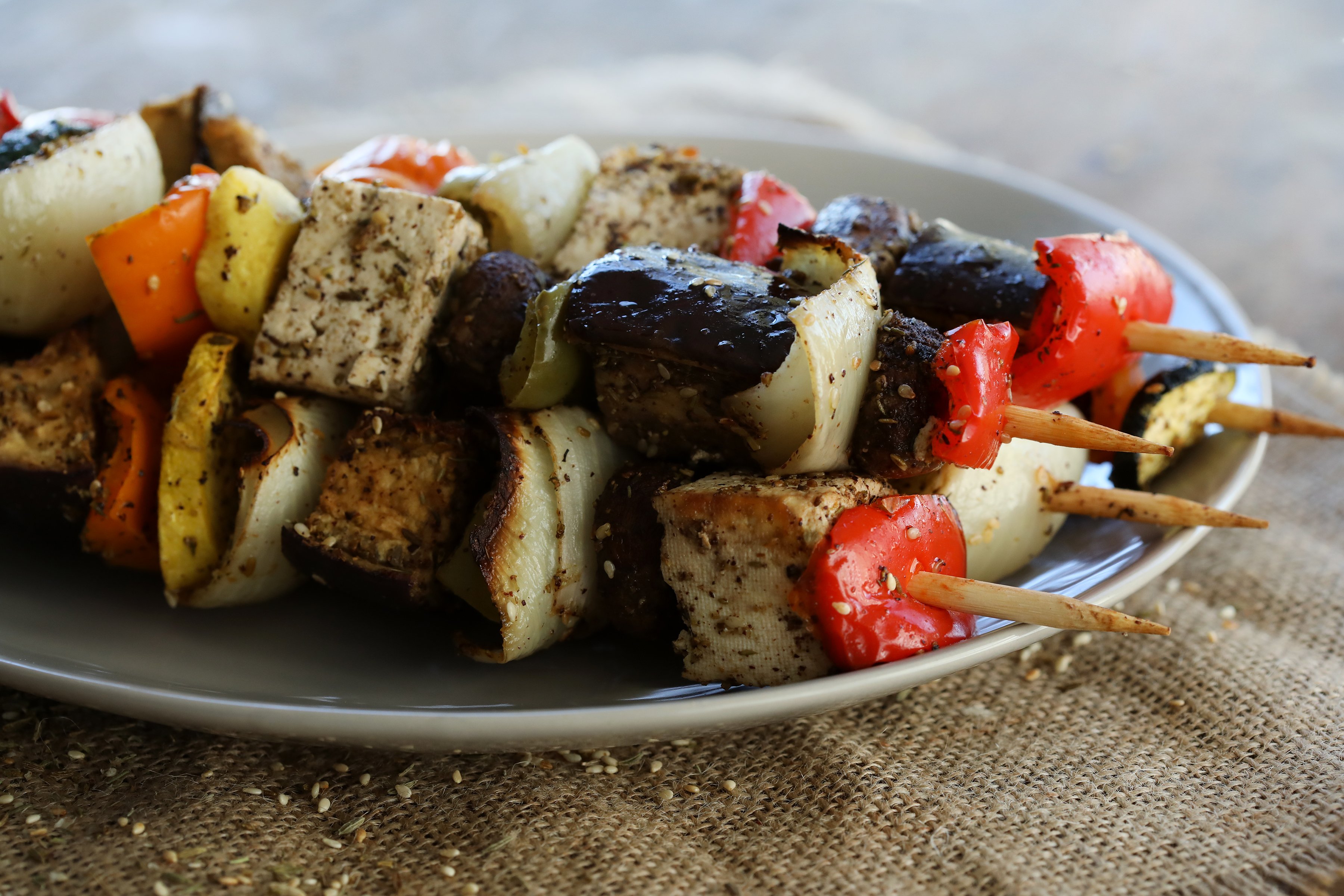 Grilled vegetable kebabs with peppers, zucchini, eggplant, and onion, resting on a plate