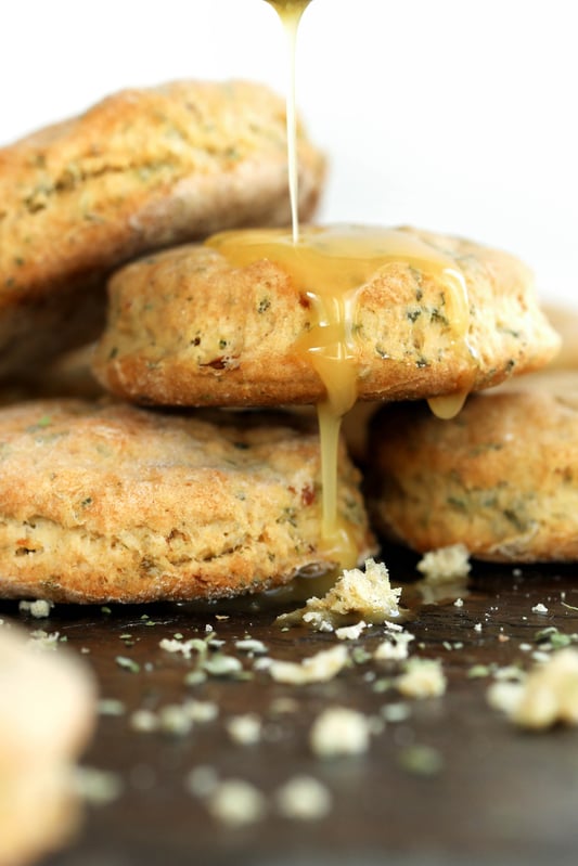 Freshly baked nettle and garlic biscuits are drizzled with raw local honey. Herbal nettle biscuits with garlic and honey. 