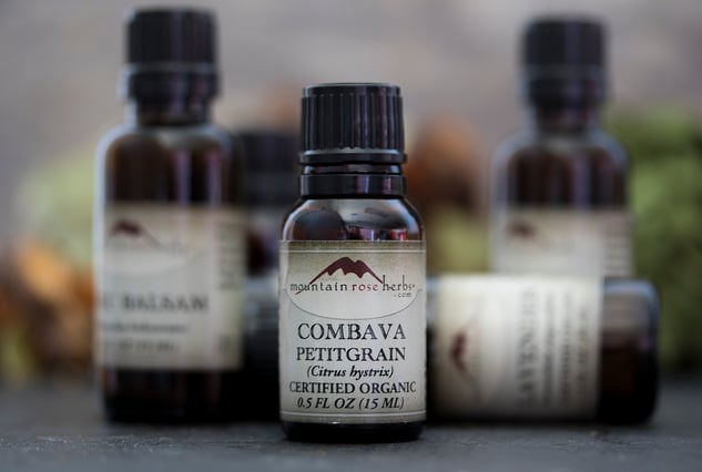 bottle of certified organic .5 oz. combava petitgrain essential oil in front of other essential oils