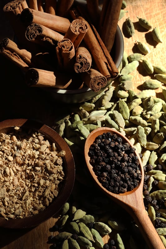 Dried herbs, spices, and berries arrayed in preparation for homebrewing.